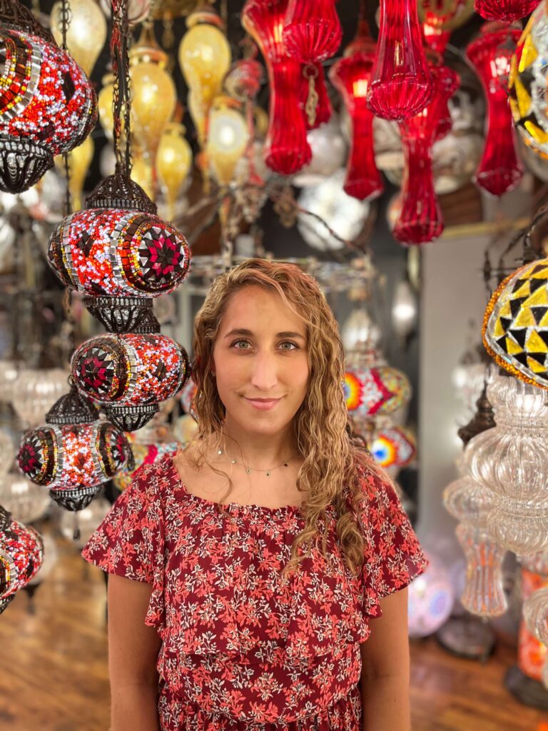 Posing in front of multiple colorful Turkish lamps in the Grand Bazaar in Istanbul, Turkey