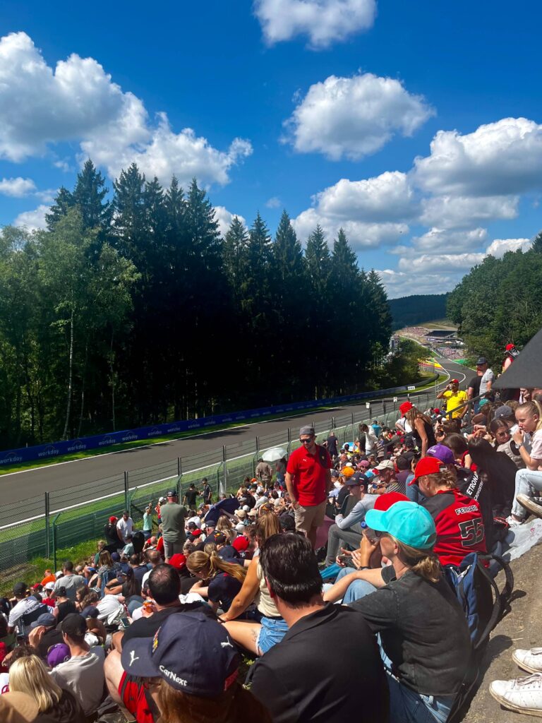 Large crowd of people sitting in the bronze area on the Kemmel Straight at the Belgian Grand Prix.